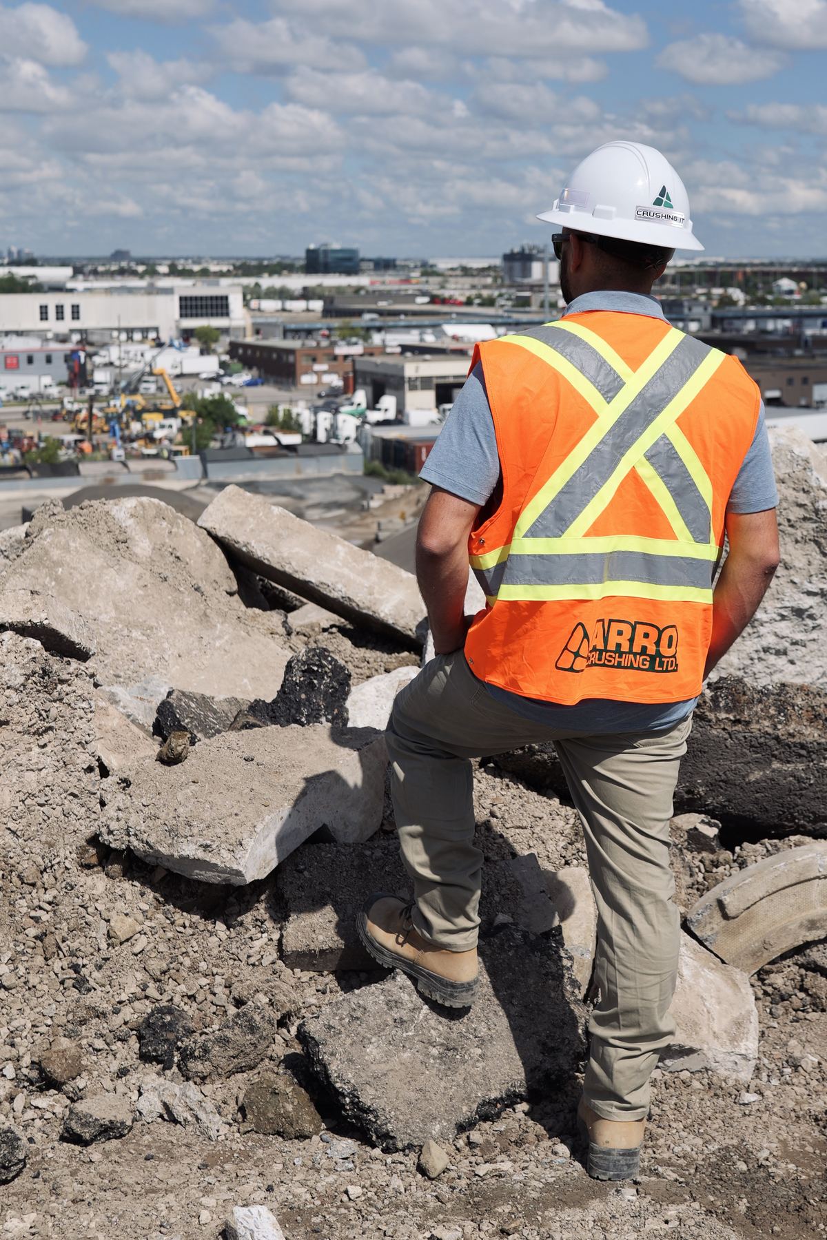 ARRO crew member in a high-visibility vest surveying a pile of broken concrete